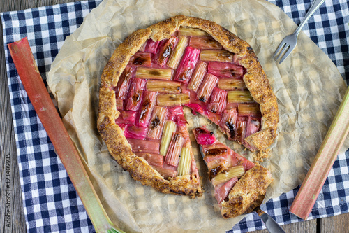 rustical rhubarb galette cake with slice on a confectionery shovel from above
