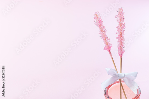 Two pink rock candy on pink paper background decorated with a white bow  copy space  horizontal
