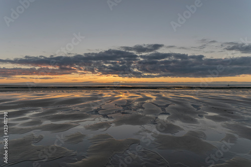 Sunset reflections on a beach with an Island on the Horizon