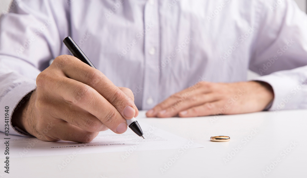 Husband signing divorce decree on white background Husband signing divorce decree on white background
