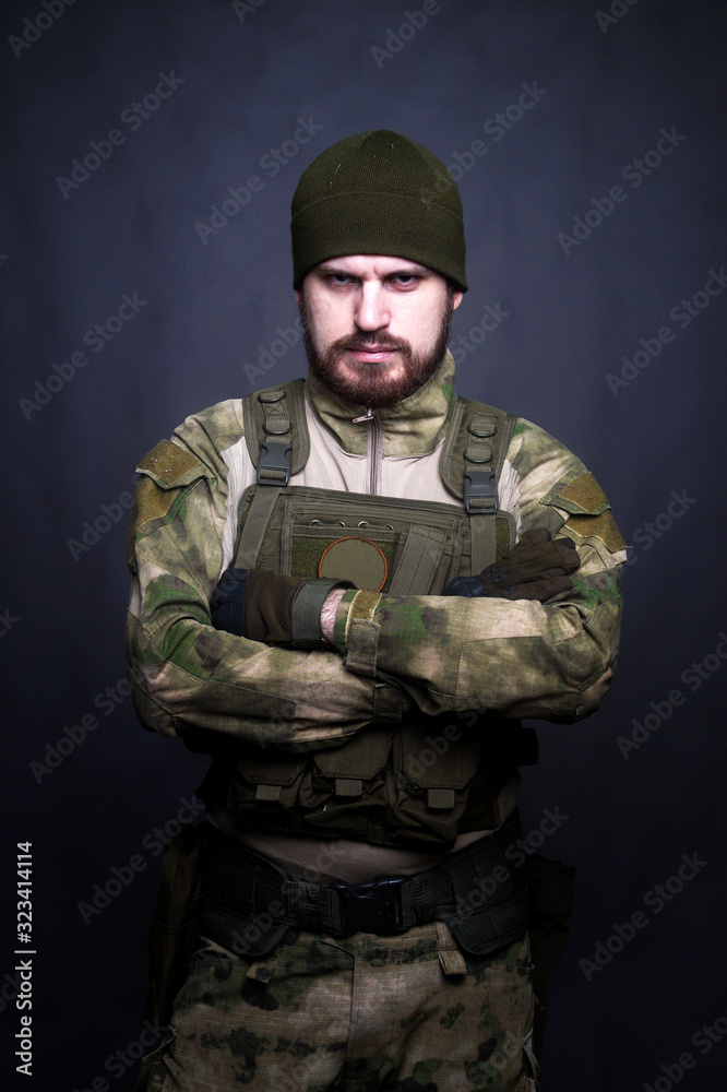 A soldier in camouflage clothing poses in a Studio A soldier in camouflage clothing poses in a Studio