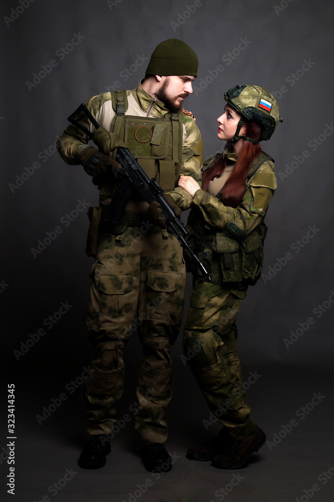 Twol soldiers in camouflage clothing poses in a Studio