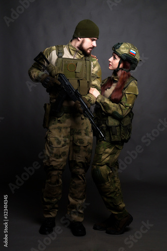 Twol soldiers in camouflage clothing poses in a Studio