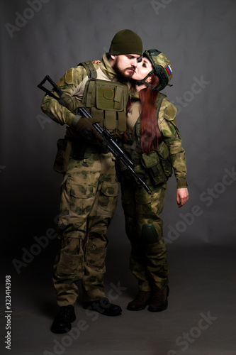 Twol soldiers in camouflage clothing poses in a Studio