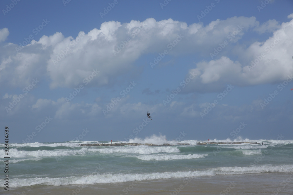 kitesurfer flies over the waves kite surfing in the sea