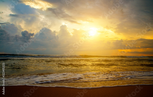 Reflection of vivid sunset sky over sea and beach.Colorful sunrise with Clouds over ocean. Pink and yellow sunset over the ocean with clouds, Sri Lanka, Asia, Ceylon