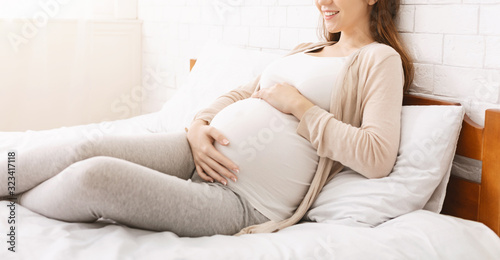 Calm pregnant woman touching her belly, panorama