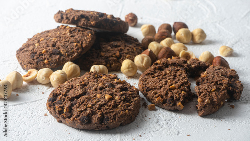 Chocolate cookies for breakfast with mint and hazelnut and a glass of milk on a gray table