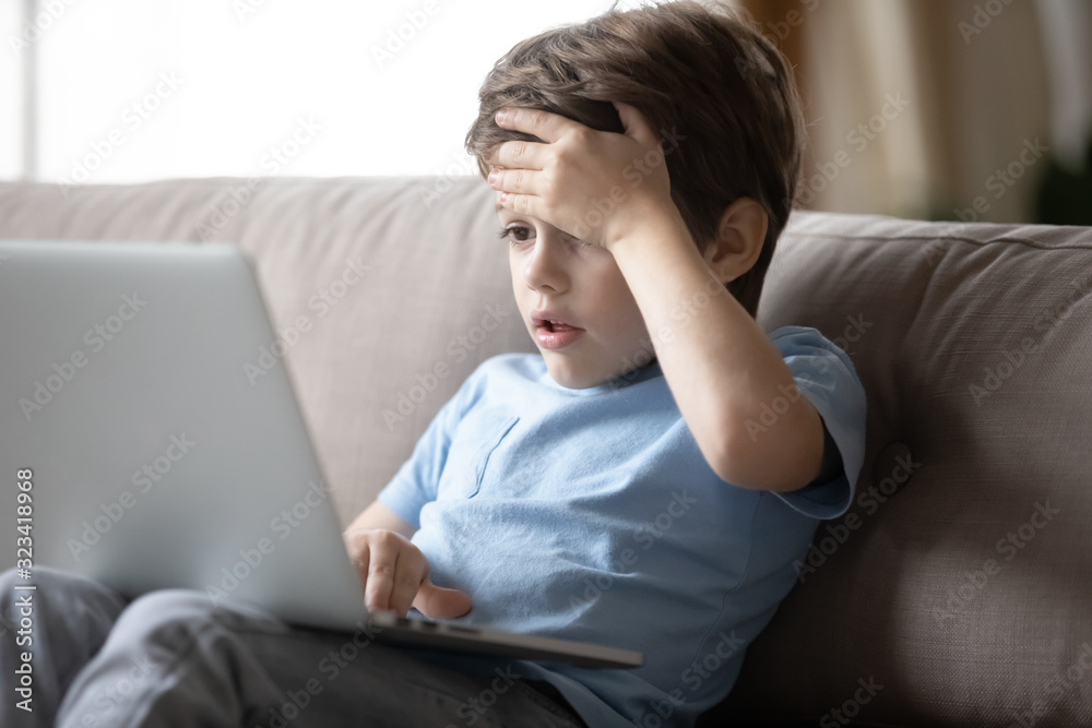 Little boy hocked by inappropriate content, looking at computer screen. Little boy hocked by inappropriate content, looking at computer screen.