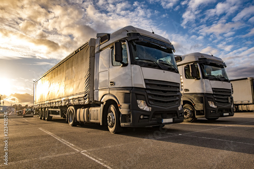 Trucks in a row with containers in the parking lot. Logistic and Transport concept © hiv360