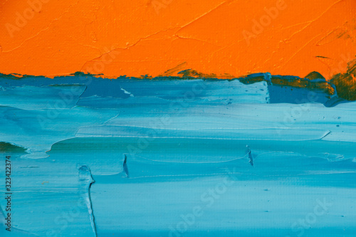 Textured background of oil paint in orange and blue tones, selective focus