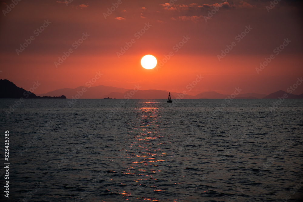 sunset over the sea with boat at horizont