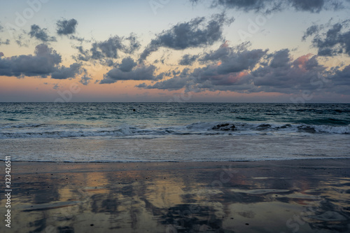 sunset at the beach with colorful clouds and waves © Denis Feldmann
