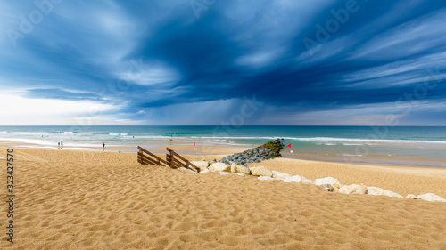Blick auf den Strand in Lacanau Océan, Frankreich, bei aufziehenden, dunklen Gewitterwolken