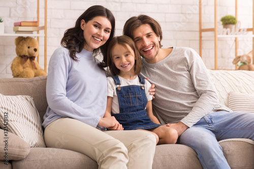 Portrait of cute little girl posing at home with her parents