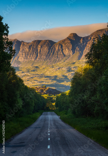 Photography The mountain range of the Knockan Crag National Nature Reserve at sunset, seen from the two-lane highway of A385 near Elphin, Lairg, Scotland