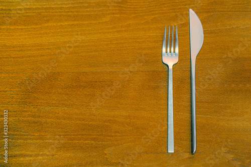 Top View of fork and Knife on wooden background. Fork and Knife on wooden background. Cutlery on wooden table. Text Space.