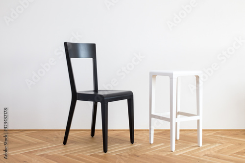 modern simplistic black and white chair on a wooden flor in front of white background
