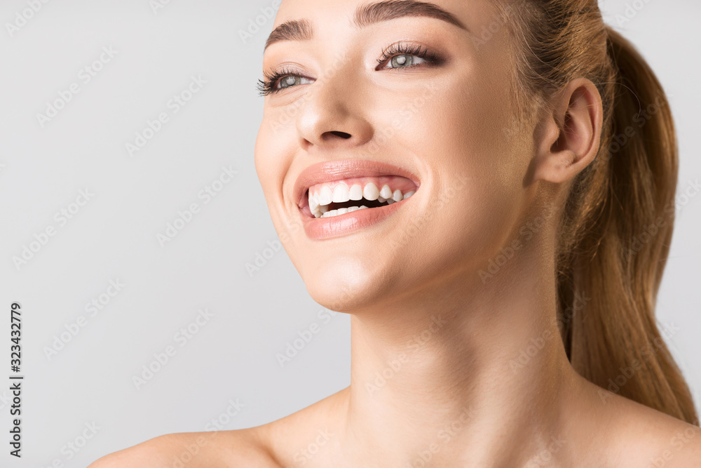 Obraz premium Beauty Portrait Of Millennial Girl Laughing On Gray Studio Background
