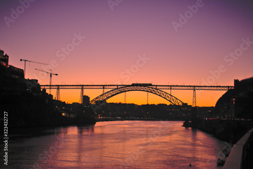 Purple and Orange sunset Dom luis Bridge and crane in Porto Portugal