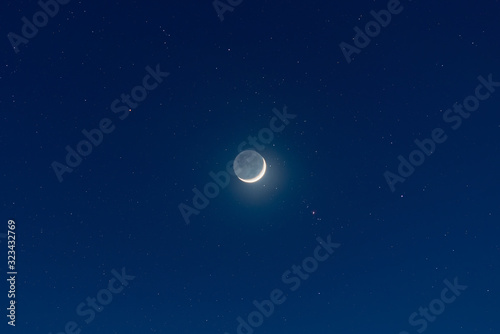 Leinwand Poster Waxing crescent moon, earthshine and starry night sky