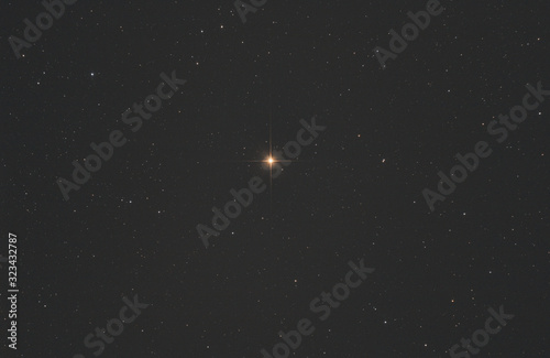 Closeup of Betelgeuse star or alpha Orionis in Orion constellation, with many stars as background in the deep space. photo