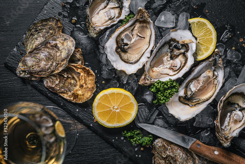 Tableau sur toile Fresh oysters with lemon ice and white wine.