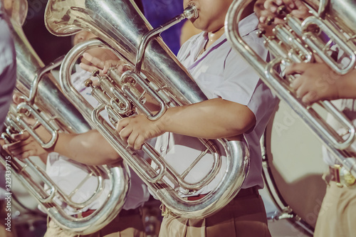 Quadro su tela Male student with friends blow the euphonium with the band for performance on stage at night