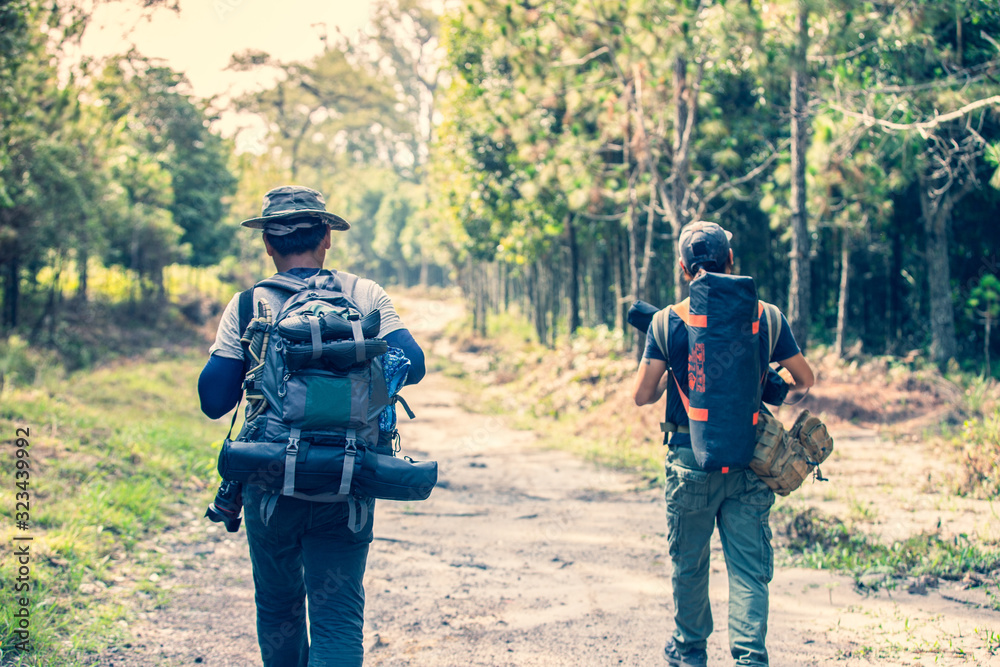 Fototapeta premium Group friend walking in the wild with a heavy backpack. Travel Lifestyle wanderlust adventure concept summer vacations in the wild