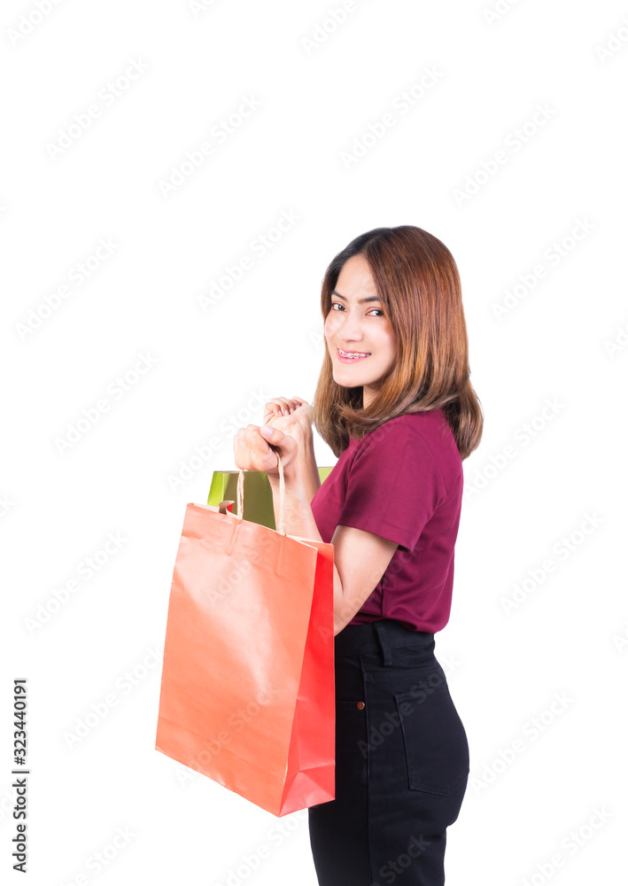 young woman pretty smiling holding paper bags green and orange shopping. on white background and looking at camera