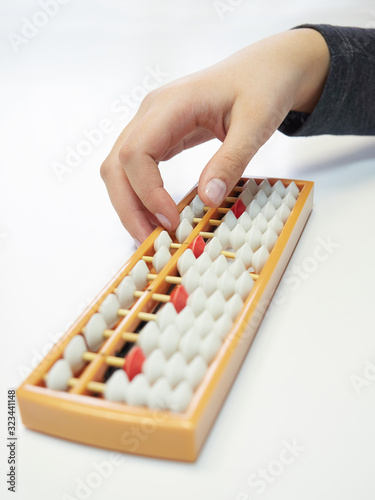 Classes in mental arithmetic  hands and abacus soroban on white background. closeup