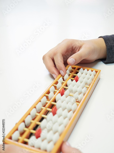 Classes in mental arithmetic  hands and abacus soroban on white background. closeup