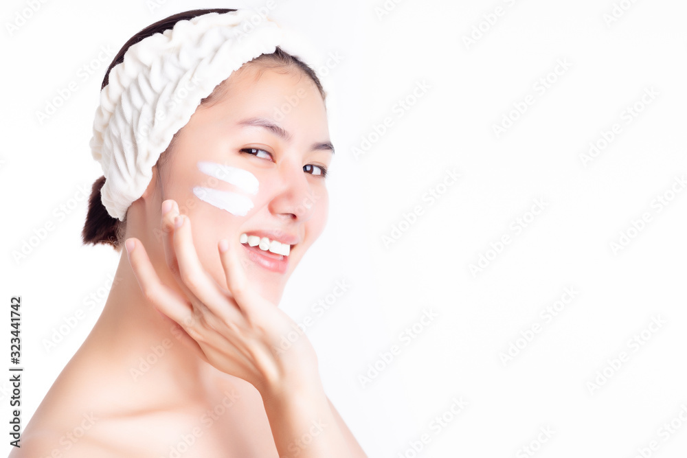 Asian woman apply cream, lotion to beautiful skin on cheek after bath. Young woman showing cream or moisturizer on face. Smiling Asia beautiful girl get happiness. She has nice skin. Skincare concept Asian woman apply cream, lotion to beautiful skin on cheek after bath. Young woman showing cream or moisturizer on face. Smiling Asia beautiful girl get happiness. She has nice skin. Skincare concept