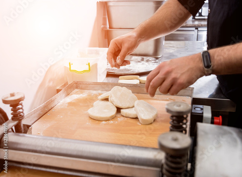 Chef preparing dough for pastry, dumplings, italian pasta or japanese wontons.