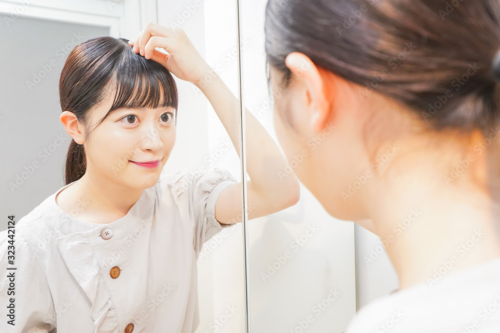髪のセットをする若い女性 髪のセットをする若い女性