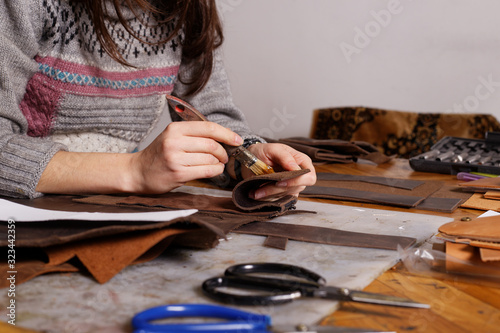Girl makes leather purse.