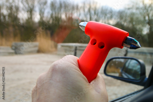 Safety hammer being used to smash window glass during car crash emergency