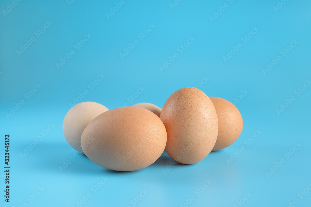 Five fresh brown chicken eggs on a blue background. Healthy good nutrition. Natural organic farm products. Five fresh brown chicken eggs on a blue background. Healthy good nutrition. Natural organic farm products.