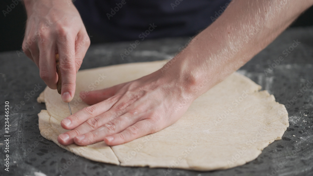 man cutting flat dough with knife man cutting flat dough with knife