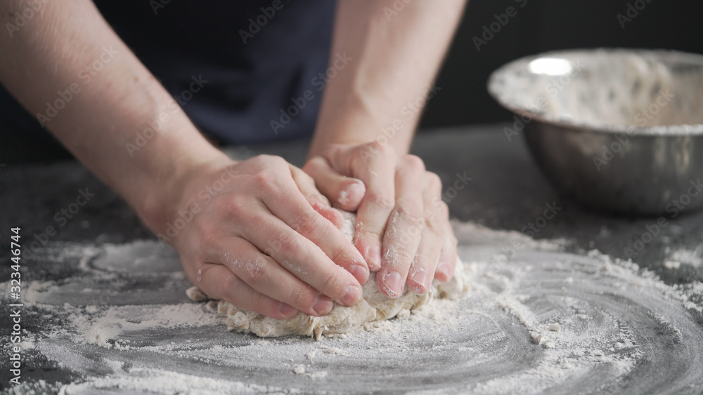 man working with dough on concrete countertop man working with dough on concrete countertop