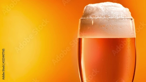 Lager beer settles in the glass with a white cap of foam photo