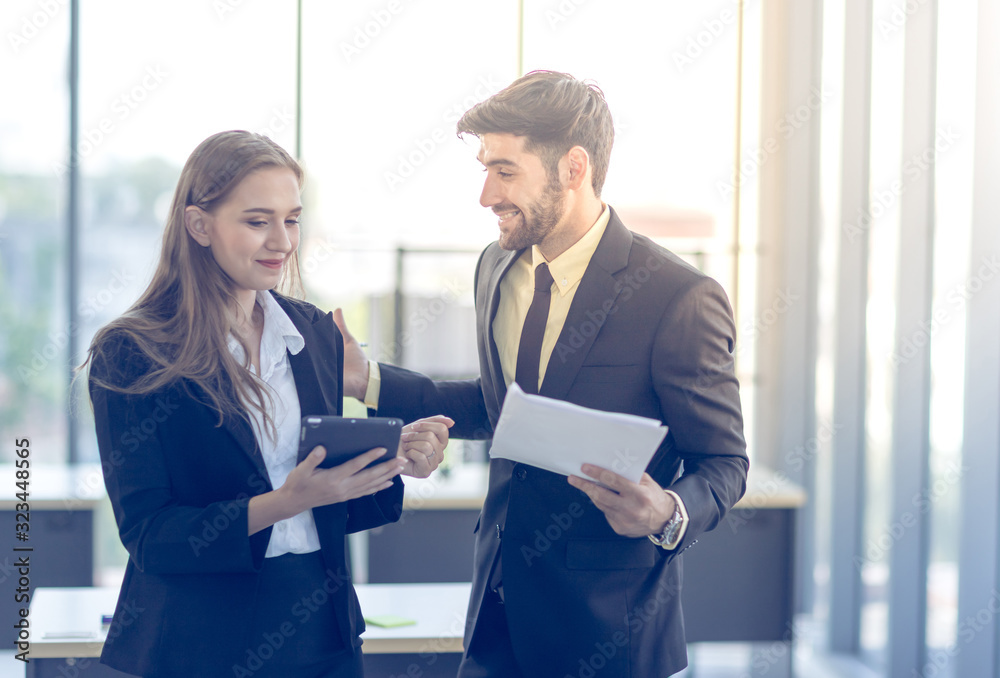 Obraz premium The young manager is talking to the female secretary in the office. Concept. Business and teamwork