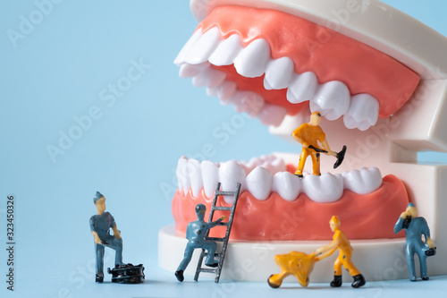 Miniature people of the teeth cleaning workers are medical and health care concepts.
