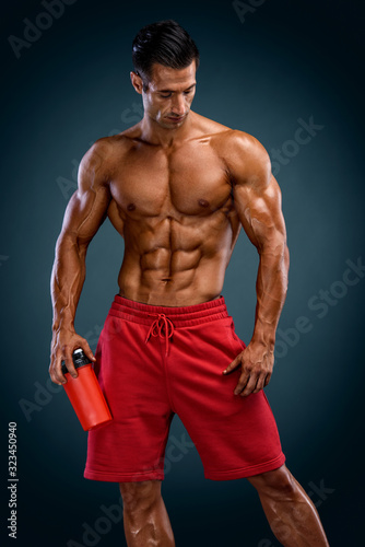 Nutritional Supplement. Muscular Men Drinks Protein, Energy Drink After Workout. Copy Space