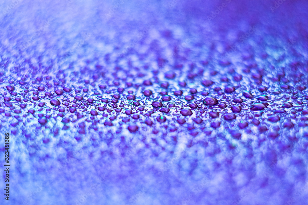 Drops on the skin. Artificial leather. Close-up of water drops. Abstract purple and blue wet texture with drops on the surface.