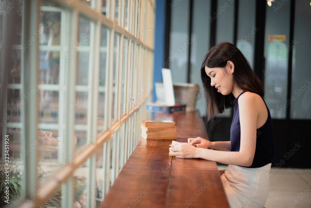 Asian woman reading a book at the coffeeshop. Asian woman reading a book at the coffeeshop.