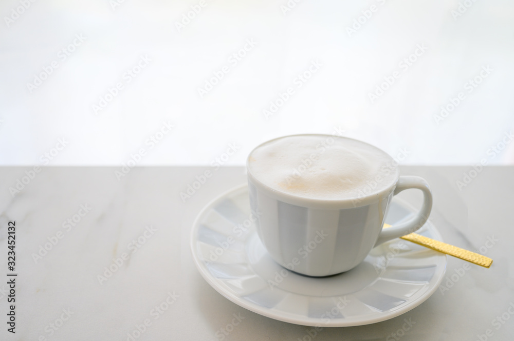 Cappuccino white cup on white table with white curtain Cappuccino white cup on white table with white curtain