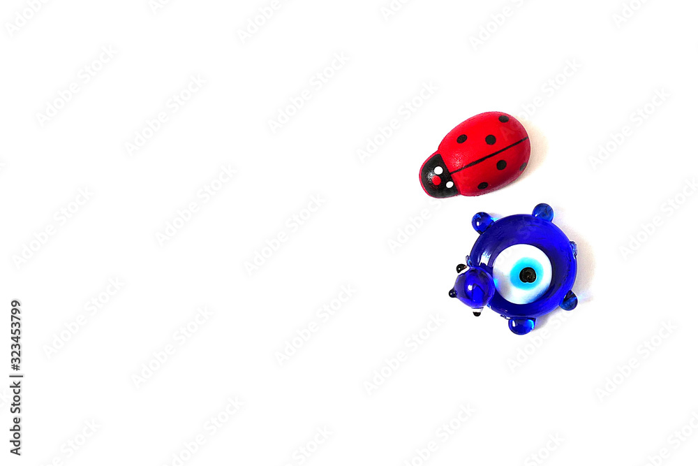 ladybug and evil eye bead on a white background, close up ladybug, evil eye bead and luck ladybug and evil eye bead on a white background, close up ladybug, evil eye bead and luck