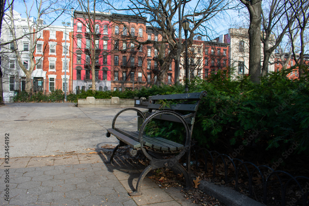 Empty Bench at Tompkins Square Park in the East Village of New York City with Colorful Buildings in the background