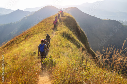 beautiful landscape with trekkers walking on mountain ridge in sunset at Khao Chang Phuak, Thong Pha Phum National Park, Kanchanaburi, Thailand photo